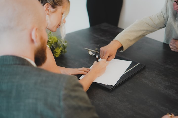 Couple signing a loan agreement with an advisor