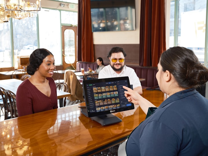 Diners using a restaurant self-order touchscreen kiosk