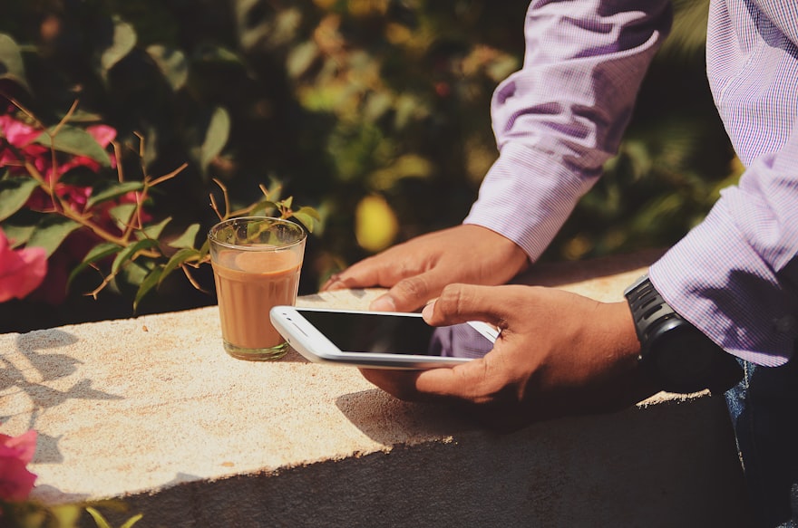 Relaxed customer waiting wherever they like, checking their queue position on their phone over coffee